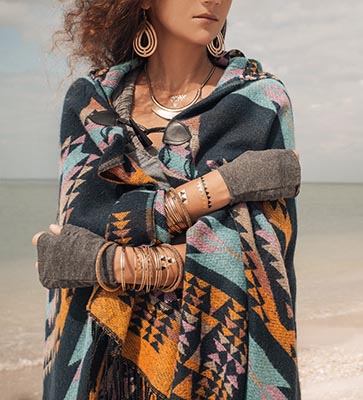 Woman on beach in poncho