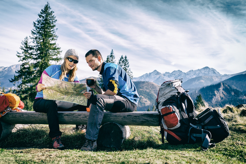 hiking couple resting looking at map